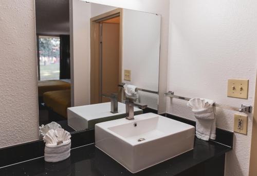 y baño con lavabo blanco y espejo. en Express Inn & Suites, en Palestine