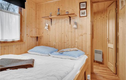 a bedroom with a bed in a wooden wall at Cozy Home In Prst With Kitchen in Præstø