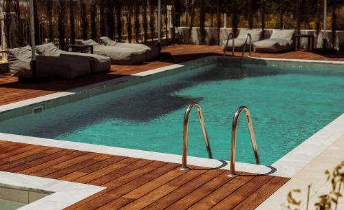 a large swimming pool with a wooden deck at Regency Boutique Hotel Holiday Suites in Paphos