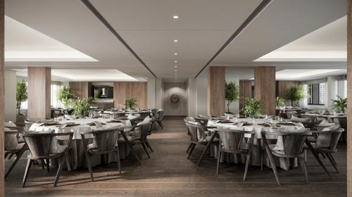um salão de banquetes com mesas e cadeiras numa sala em 1 Hotel Mayfair em Londres