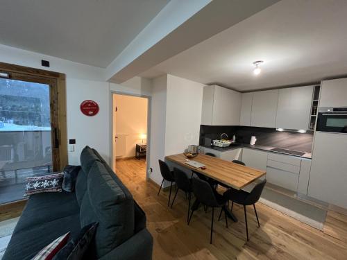 un salon avec un canapé et une table avec des chaises dans l'établissement Résidence de l'Ariondaz - Courchevel, à Courchevel