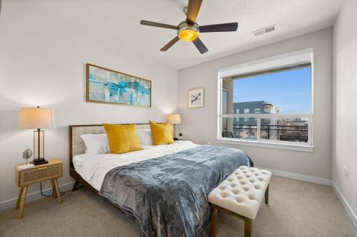 a bedroom with a bed with a ceiling fan and a window at Downtown Walking Oasis with King BD and City View in Salt Lake City