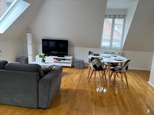 a living room with a couch and a table with chairs at Coeur de bouchon in Troyes
