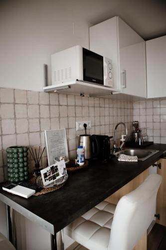 a kitchen counter with a sink and a microwave at Sipos Borház és Vendégház in Badacsonyörs