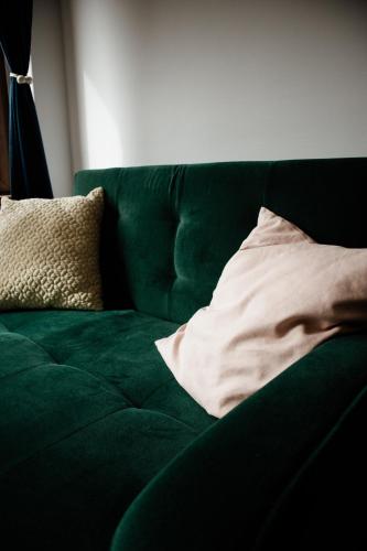 a green couch with a pillow on top of it at Sipos Borház és Vendégház in Badacsonyörs