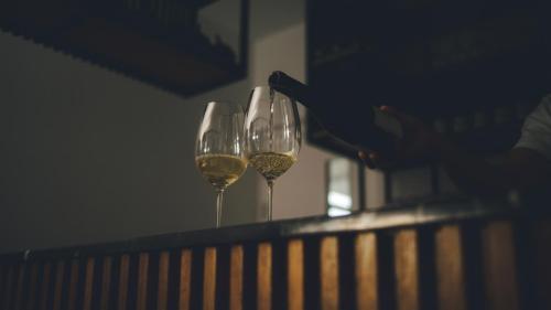 three glasses of wine sitting on a rail at Regency Boutique Hotel Holiday Suites in Paphos