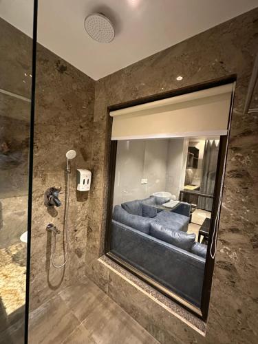 een badkamer met een douche en een grote spiegel bij Belvedere Suites in Greater Noida