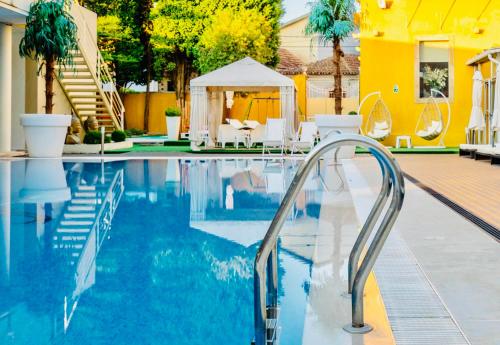 a swimming pool with a stairway leading to a yellow house at Plaza House Ílhavo in Ílhavo