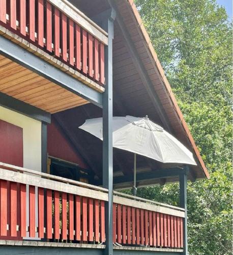 a white umbrella sitting on the porch of a house at Ferienhaus Rhöner Wohnen in Hilders
