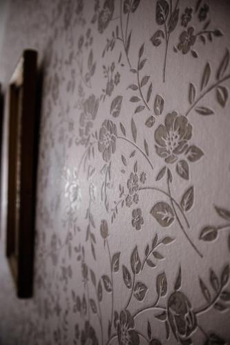 a wall with a flower pattern on a wall at Sipos Borház és Vendégház in Badacsonyörs