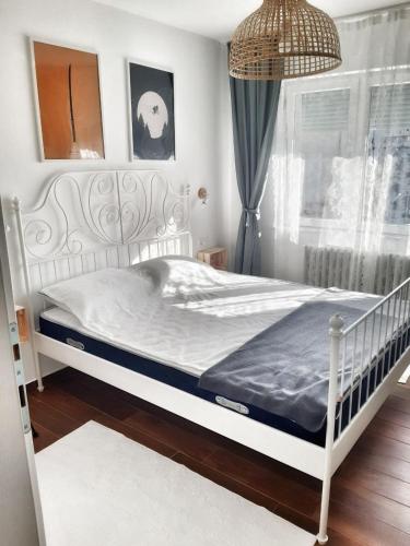 a white bed in a room with a window at Home Apartment LUNA in Skopje