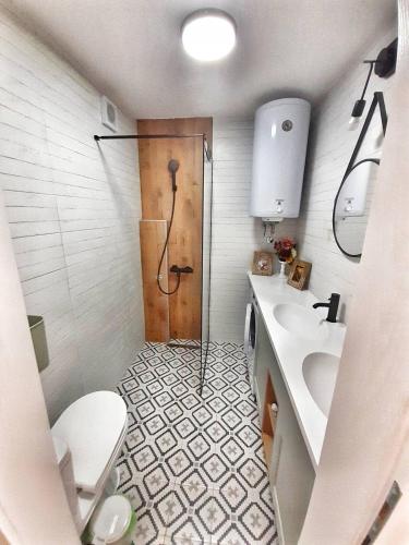 uma casa de banho com um chuveiro, um WC e um lavatório. em Home Apartment LUNA em Skopje