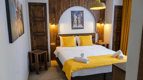 a bedroom with a bed with yellow sheets and yellow pillows at Wind Of Alaçatı in Cesme