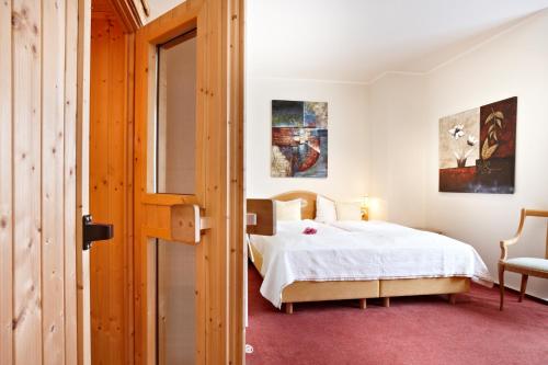 a bedroom with a white bed and a window at Hotel Dänischer Hof Altenholz by Tulip Inn in Altenholz
