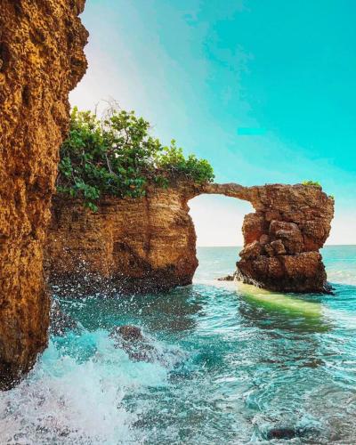 an arch in a rock formation in the ocean at Casamares Private Room Mar with Pool and Barbecue 5 min to Boqueron and Beaches in Cabo Rojo