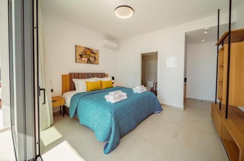a bedroom with a bed with a blue blanket at Regency Boutique Hotel Holiday Suites in Paphos