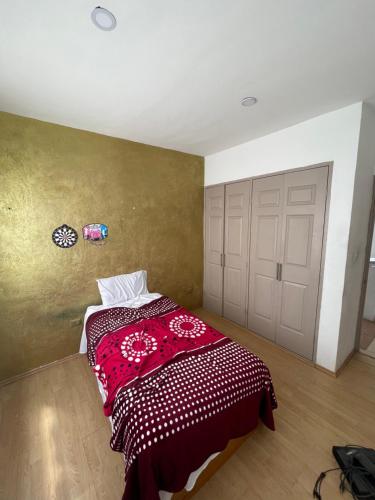 a bedroom with a bed with a red blanket on it at Casa en Condominio privado en renta por temporada de feria in Aguascalientes