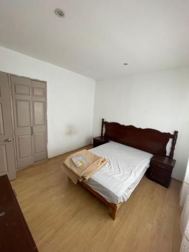 a small bedroom with a bed and a wooden floor at Casa en Condominio privado en renta por temporada de feria in Aguascalientes