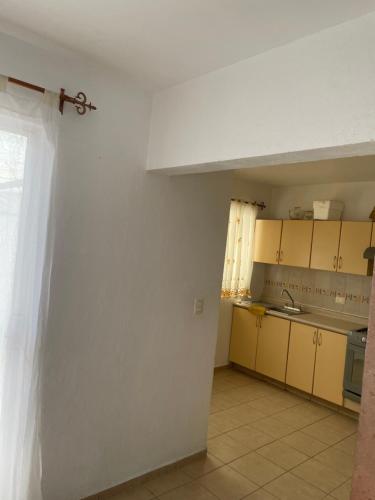 a kitchen with yellow cabinets and a white wall at Casa en Condominio privado en renta por temporada de feria in Aguascalientes