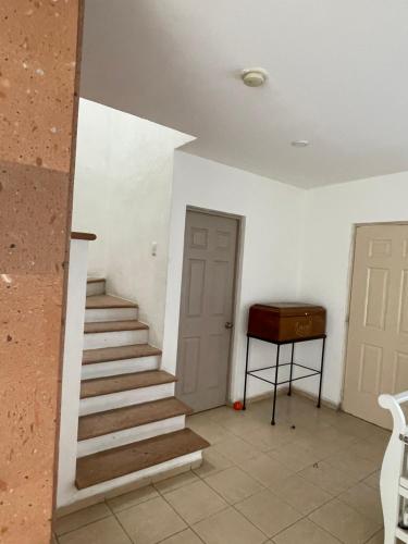 a staircase in a room with a door and a table at Casa en Condominio privado en renta por temporada de feria in Aguascalientes