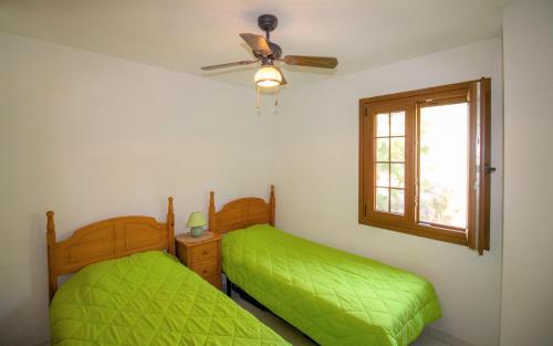 a bedroom with two beds and a window at Terraza con vistas espectaculares - Haciendas ALBERT VILLAS Alcossebre in Alcossebre