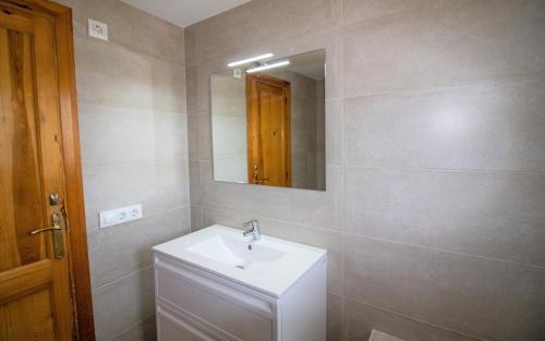 a bathroom with a white sink and a mirror at Terraza con vistas espectaculares - Haciendas ALBERT VILLAS Alcossebre in Alcossebre