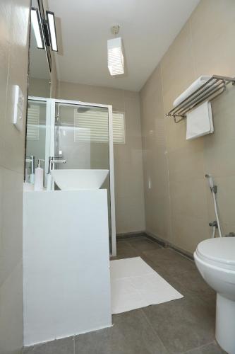 a bathroom with a glass shower and a toilet at The Beach house by Kay Jay Hotels in Pasikuda