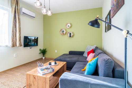 uma sala de estar com um sofá azul e uma mesa de centro em Madrid 2BDR near Metro, Serdika Mall - ACs - Cot em Sófia