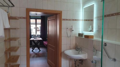 a bathroom with a sink and a mirror at Der grüne Fürst Ferienwohnung Apartment 1 in Bad Muskau