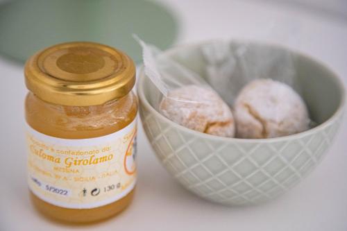 a jar of honey next to a bowl of donuts at Light Garden in Taormina