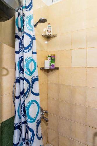 a bathroom with a shower with a blue and white shower curtain at Madrid 90 Sq M 2BDR w Parking Spot near Metro, Serdika Mall in Sofia