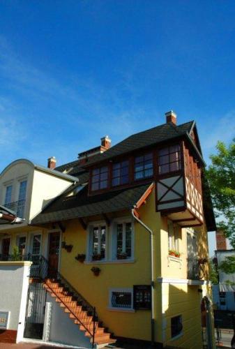 a large yellow house with a black roof at Villa Europa in Mielno