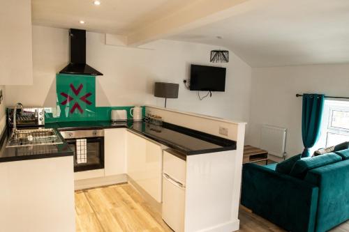 a kitchen with a blue couch in a room at Victoria Street Apartments in Morecambe