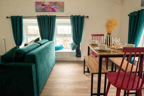 a living room with a green couch and a table at Victoria Street Apartments in Morecambe