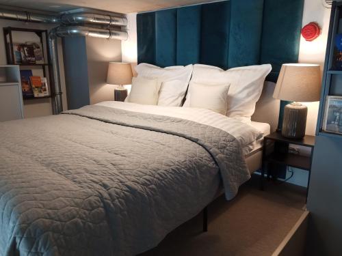 a bedroom with a large bed with a blue headboard at Wroclove Airport Loft in Wrocław