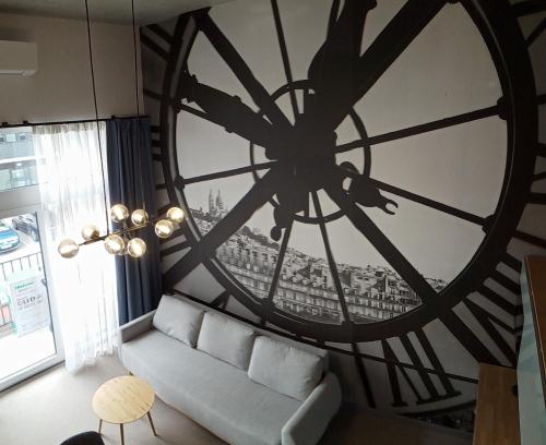 un soggiorno con un grande orologio sul muro di Wroclove Airport Loft a Breslavia