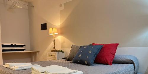 a bedroom with a bed with red and blue pillows at Le Dimore Del Gufo - La Cattedrale in Venosa