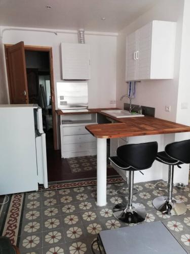 a kitchen with a table and two bar stools at Studio tout confort dans le centre historique in Prats-de-Mollo-la-Preste
