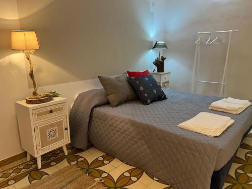 a bedroom with a bed and a lamp on a night stand at Le Dimore Del Gufo - La Cattedrale in Venosa