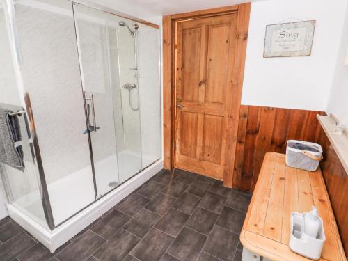 a bathroom with a shower and a wooden bench at Y Felin in Haverfordwest