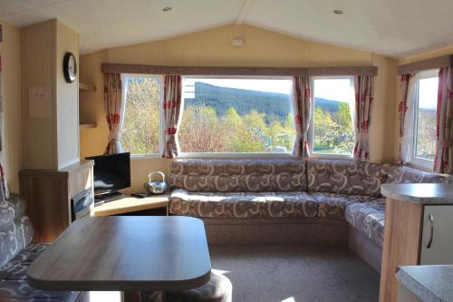 a living room with a couch and a large window at Crannich Holiday Caravans in Killichronan