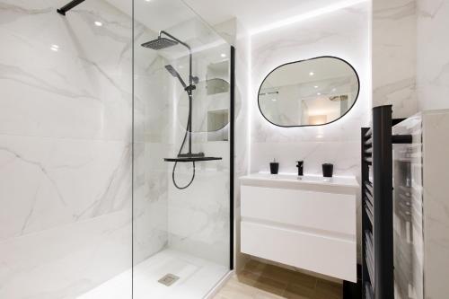 une salle de bain blanche avec une douche et un lavabo dans l'établissement Perle Dorée YourHostHelper, à Cannes