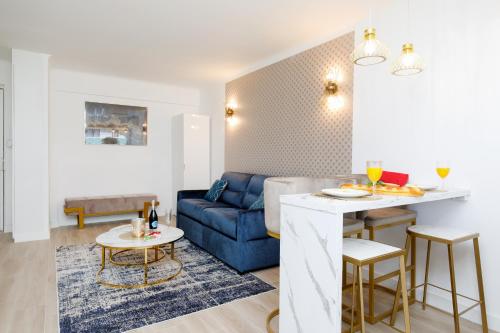 un salon avec un canapé bleu et une table dans l'établissement Perle Dorée YourHostHelper, à Cannes