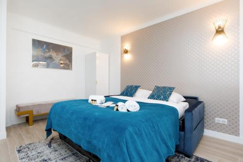 une chambre avec un grand lit avec des draps bleus dans l'établissement Perle Dorée YourHostHelper, à Cannes