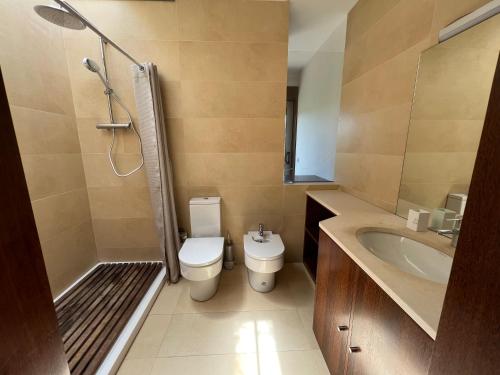 a bathroom with a toilet and a sink and a shower at Villa Martins in Lagoaça