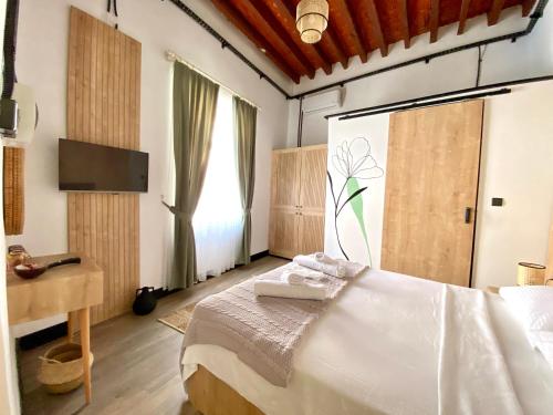 a bedroom with a bed and a desk and a television at The Port Of Kyrenia Hotel in Kérynia