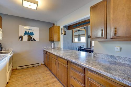 a kitchen with wooden cabinets and a counter top at Charming Townhome - Walk to Greek Peak Mountain! in Cortland