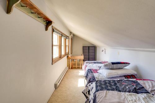 um quarto com três camas e uma janela em Charming Townhome - Walk to Greek Peak Mountain! em Cortland