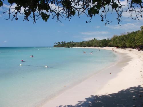 a group of people in the water on a beach at ATOAS - Lovely Vacation Retreat with Pool and Barbecue 5 min to Boqueron and Beaches in Cabo Rojo