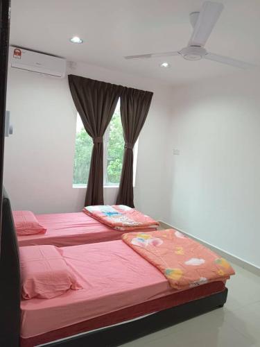 two beds in a room with a window at EMERALD VILLA HOMESTAY DUNGUN in Batu Lima